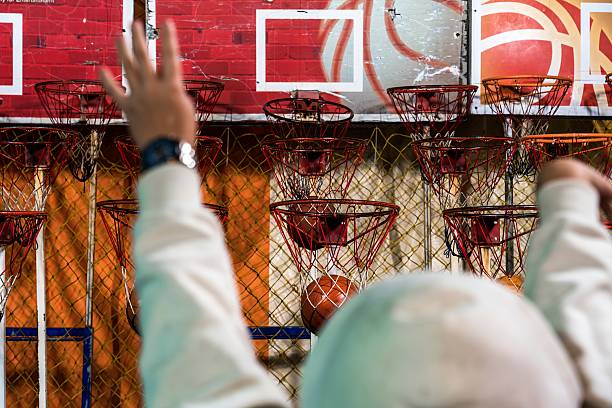 Player aiming at multiple basketball hoops in amusement arcade in taiwan
