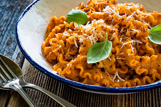 Creamy tomato and stracciatella reginelle noodles on wooden table