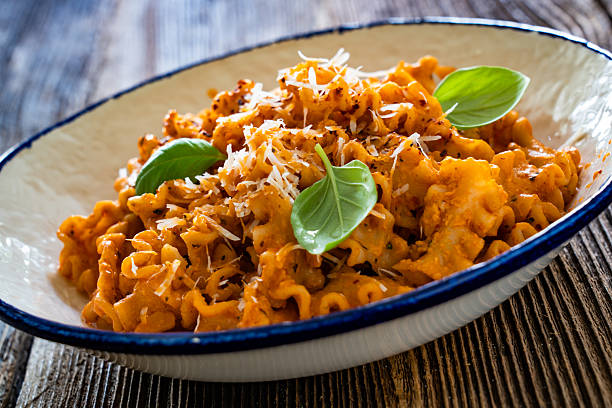 istock Creamy tomato and stracciatella reginelle noodles on wooden table 2225327144