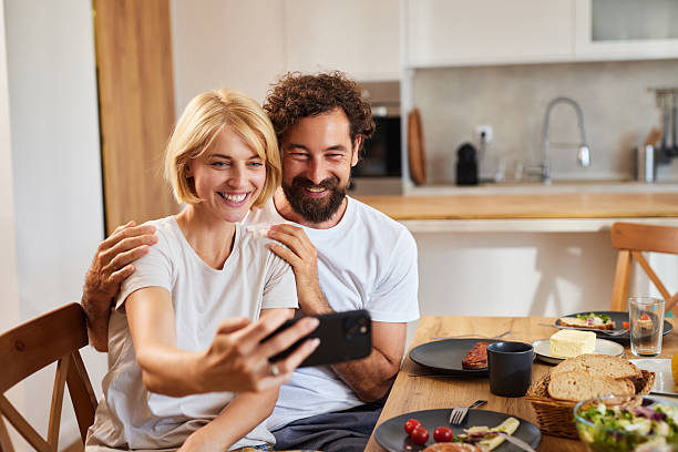 istock Couple enjoying breakfast together while taking a selfie in a cozy kitchen 2225328163