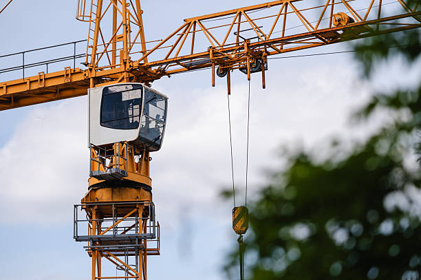 istock Modern tower crane with operator cabin against cloudy sky 2225328747