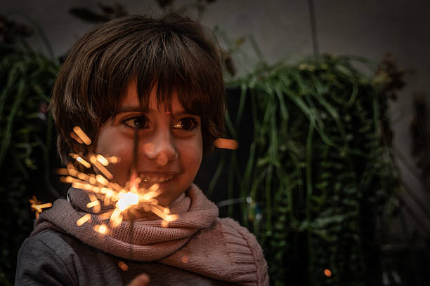 Portrait of a joyful child holding a sparkling sparkler, celebrating the festive spirit of yule with happiness and light