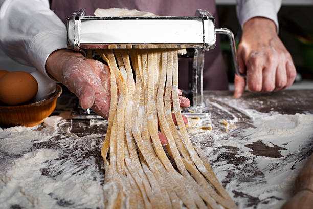 istock Caucasian female hands making fettuccine noodles using mechanical pasta machine 2225331714