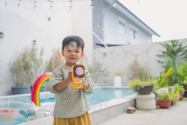 istock Asian toddler Boy playing with soap bubbles in summer Little boy playing with soap bubble machine at the backyard garden with freshness moment in summer 2225337329