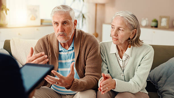 istock Elderly couple, consultation or therapist with tablet on sofa for therapy session or counseling. Senior, man and woman talking with counsellor for communication or discussion at retirement home 2225338666