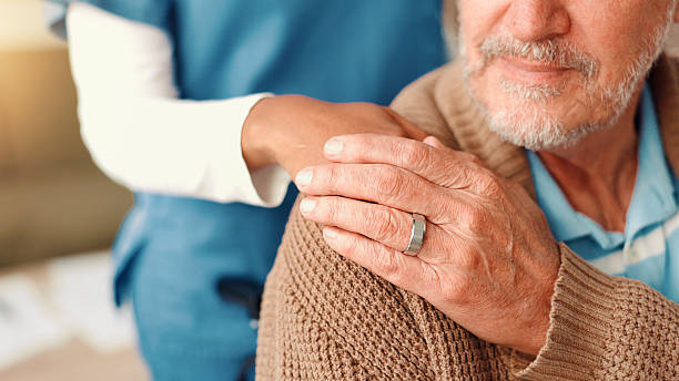 istock Hands, shoulder and nurse with elderly person on sofa for comfort, empathy and support. Retirement home, healthcare and caregiver with patient for medical care, help and compassion in assisted living 2225338684