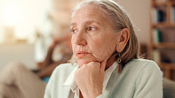 istock Thinking, sad and memory with old woman on sofa for Alzheimer, retirement and reflection. Nostalgia, depression and loneliness with senior person in living room of home for dementia and mental health 2225338687