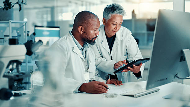 istock Collaboration, scientists and team with tablet, lab or discussion for medical research for analysis. Healthcare, science and mature people with tech for biotechnology, breakthrough and communication 2225338961