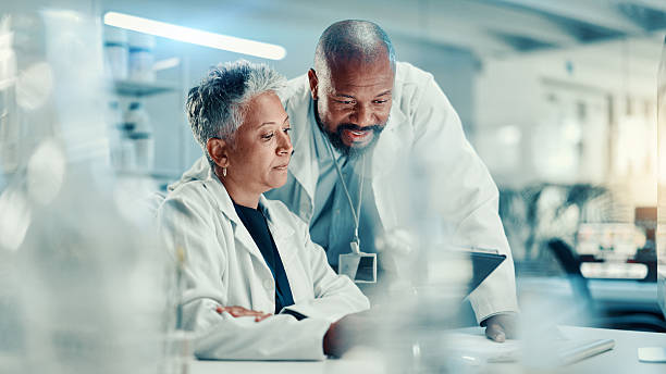 istock Analysis, collaboration and scientists with tablet, lab or discussion for medical research for team. Healthcare, science and mature people with tech for biotechnology, breakthrough and communication 2225338999