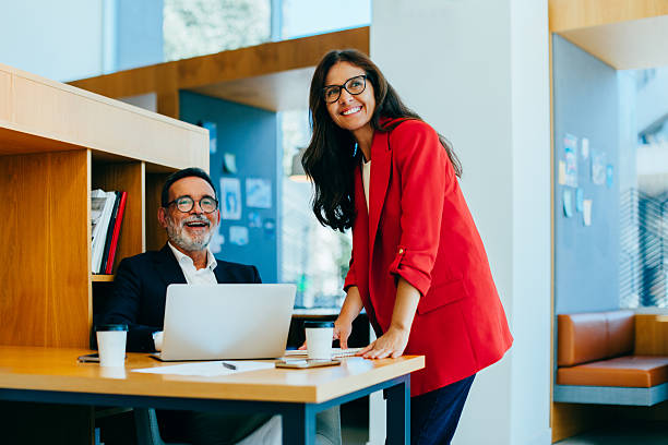 istock Smiling colleagues engaging in a productive discussion in a professional office setting 2225339301