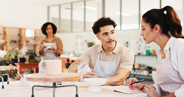 istock Pottery, class and people with clay in workshop for teaching, learning and skills development. Creative, studio and man and woman with ceramic mold for design, sculpture and DIY hobby in art lesson 2225339373