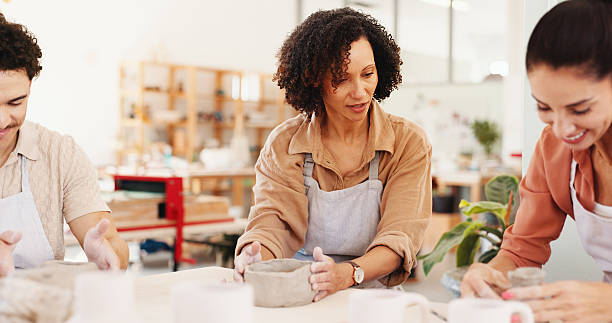 istock Pottery class, clay and people in workshop, conversation and help with sculpture mold. Business owner, artist and ceramic retail store with advice, talking or learning manufacturing with technique 2225339466