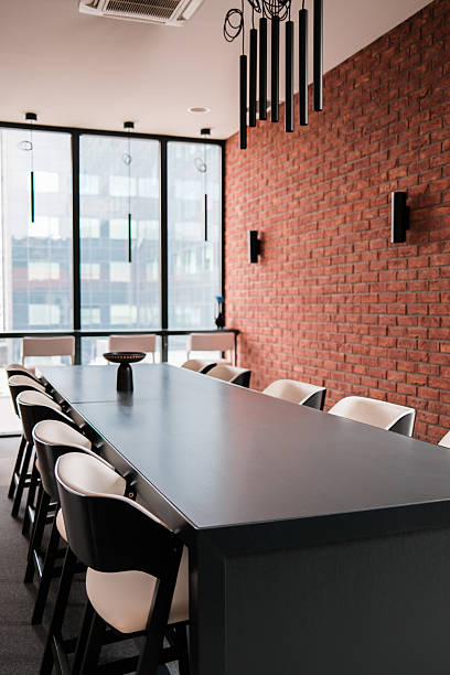 istock Conference room with long table and brick wall featuring modern lighting and chairs 2225339799
