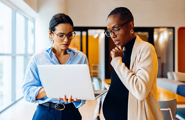 istock Two professionals working together discussing information on a laptop in an office 2225340083