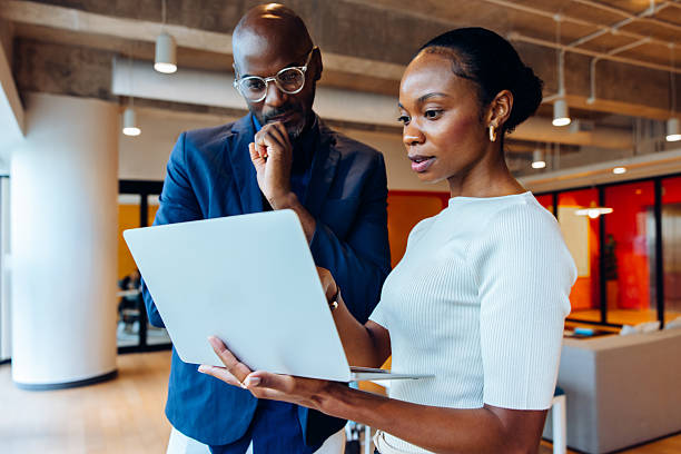 istock Two professionals discussing work details while looking at a laptop in an office 2225340742