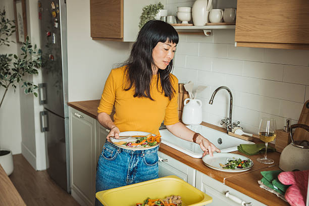 istock A young cheerful woman washing dishes 2225342883