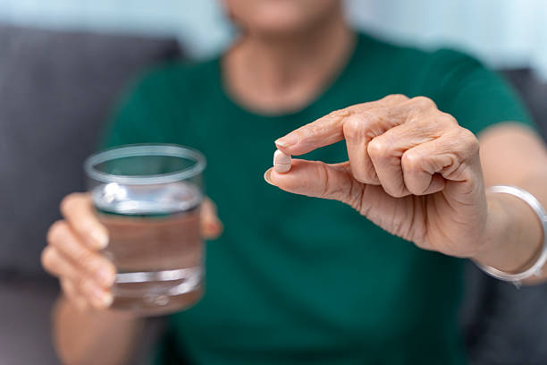 istock Senior Woman Holding Pill and Water 2225344447