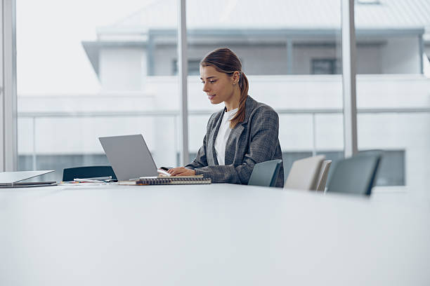 istock Focused business woman working on laptop while sitting in modern office 2225351927