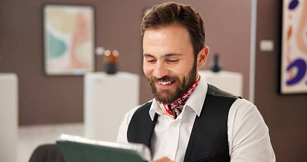 istock Smile, man and reading on tablet at art gallery for research, artwork information and schedule event. Male curator, digital and artifact collection, online auction and showroom catalog for exhibition 2225352595