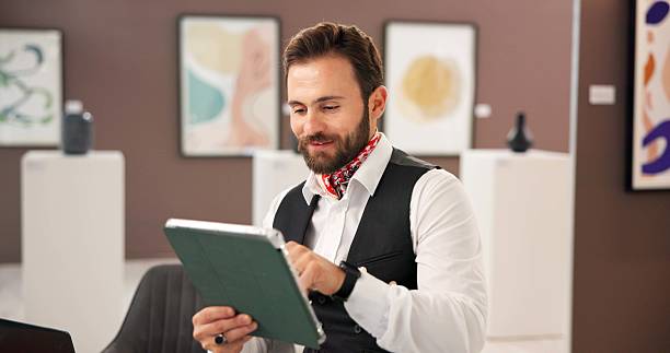 Man, art and reading on tablet at gallery for artifact research, artwork information and schedule event. Male curator, digital and review collection, online auction and showroom catalog of exhibition