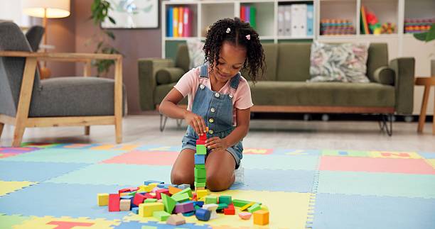 istock Child, block and building with toys for fun activity or playing on floor at elementary school. Black girl, kid or student with shapes for playful learning, fine motor skills or education in classroom 2225352947