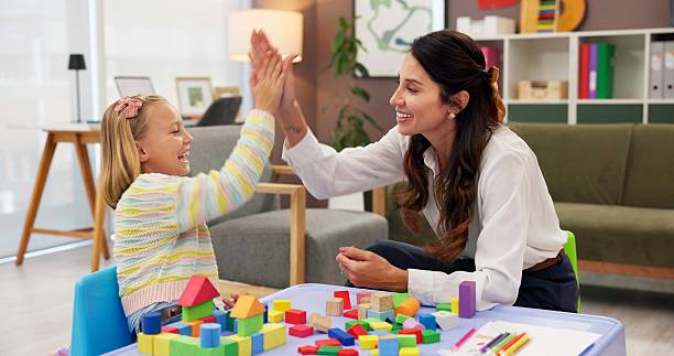 istock Therapist, child and building blocks for high five, celebration and progress in office. Psychologist woman, pediatrics and girl for toys, clinic or consultation for patient support or development 2225352993