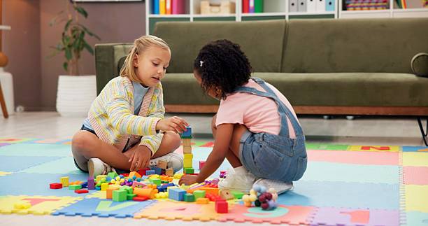 Building blocks, fun and children in psychology waiting room with cognitive development or growth. Friends, creative and girl kids playing with educational toys for sensory or motor skills at clinic.