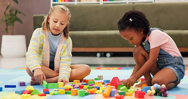 istock Building blocks, fun and kids in psychology waiting room with cognitive development or growth. Friends, creative and girl children playing with educational toys for sensory or motor skills at clinic. 2225353030