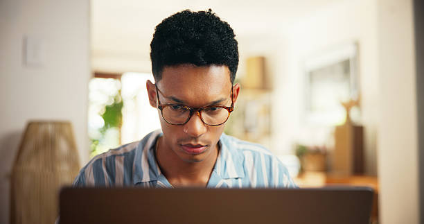 istock Man, reading and laptop for remote work at house for research, proofreading article and information. Journalist, online and review news for story update, editing draft and schedule for publication 2225353833