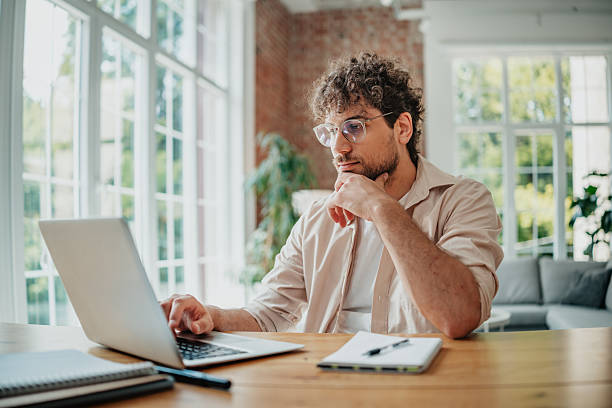 istock Young man focused on freelance work in modern home office during a productive afternoon 2225356167