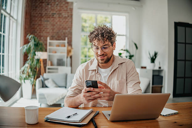 istock Young man engaging in freelance work at home office with modern decor and natural light 2225357728