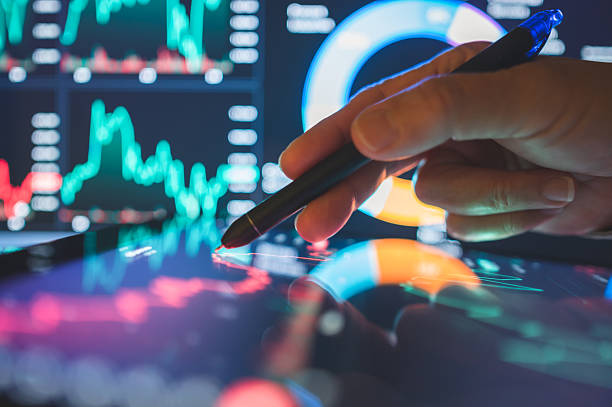 istock hand using digital pen to analyze stock market graph  investor interacting with ai-powered trading dashboard featuring real-time market data 2225358286