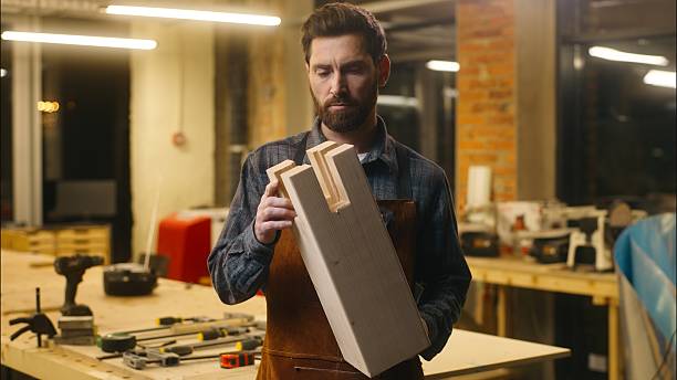 istock Caucasian carpenter builder wood master man holding wooden craft in workshop joiner worker male looking at handmade furniture hardwood handicraft art guy craftsman artist woodworking hobby carpentry 2225360789