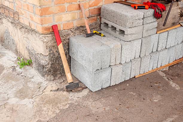 istock A collection of construction tools and materials are positioned near a brick building. 2225360800