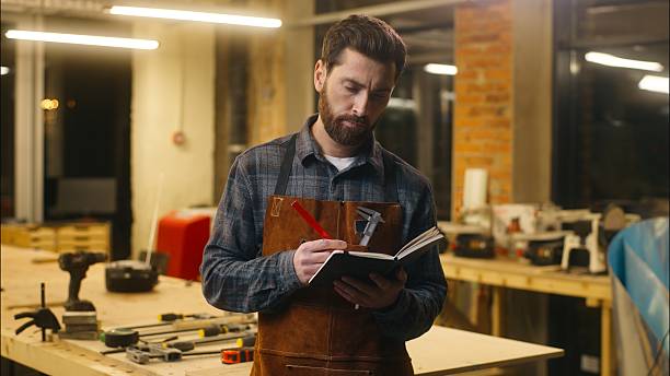 istock Pensive Caucasian worker male wood master workman man guy carpenter writing notebook puzzled handyman planning work small business in workshop craftsman thinking builder contemplating artwork industry 2225362332