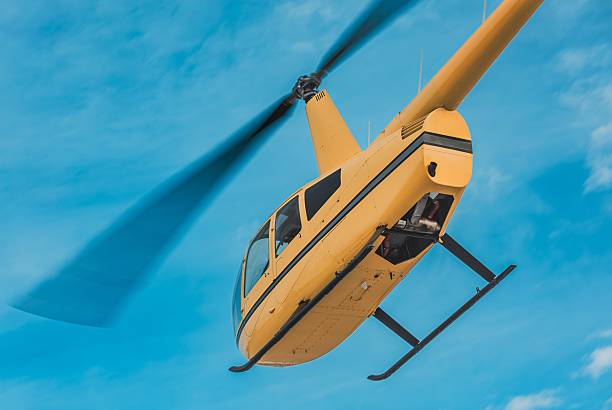 istock Yellow helicopter climbing through blue sky – close-up 2225363155