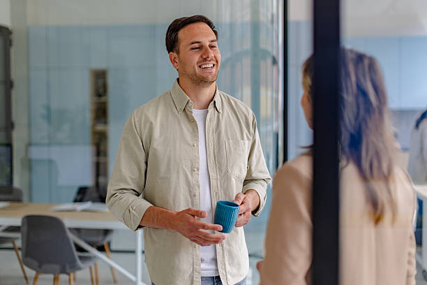 istock Colleagues engage in conversation while enjoying coffee in a modern office environment focused on teamwork and collaboration 2225364710