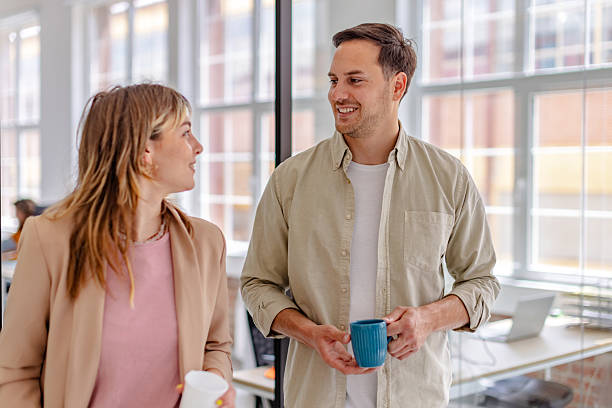 istock Colleagues engage in conversation while enjoying coffee in a modern office setting during work hours 2225364857