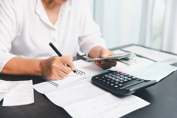 istock Using calculating machine, household carefully manages each bill and expense to plan financial budget, ensuring timely payment, consistent saving, smart investment for secure home finance strategy. 2225366563