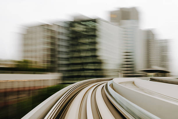 Dynamic image capturing a monorail track in a modern city with blurred motion, showcasing futuristic transportation and speed in an urban environment.