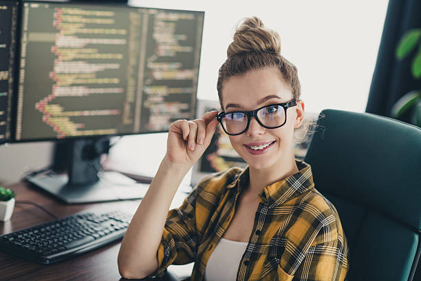 istock Young woman programmer in casual attire working on her computer in a home office environment, smiling confidently 2225367071