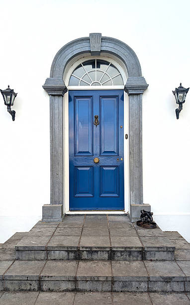istock A Traditional victorian styled striking blue front door framed by gray stone adorns the entryway of a building. Two decorative lanterns illuminate the area 2225368830