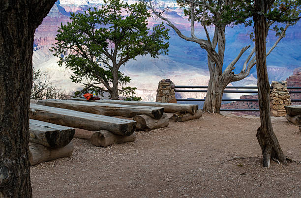 Rows of sturdy log benches add to the rustic nature and provide sturdy seating for tourists to rest and contemplate the surrounding beauty. Bokeh.