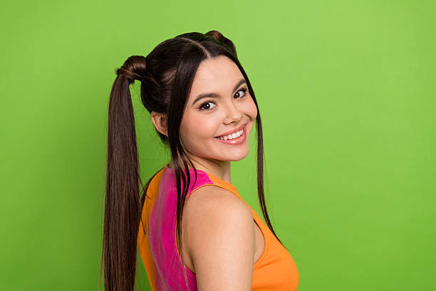istock Bright green backdrop featuring a stylish young woman with a cheerful expression and colorful outfit for trendy concepts 2225369741