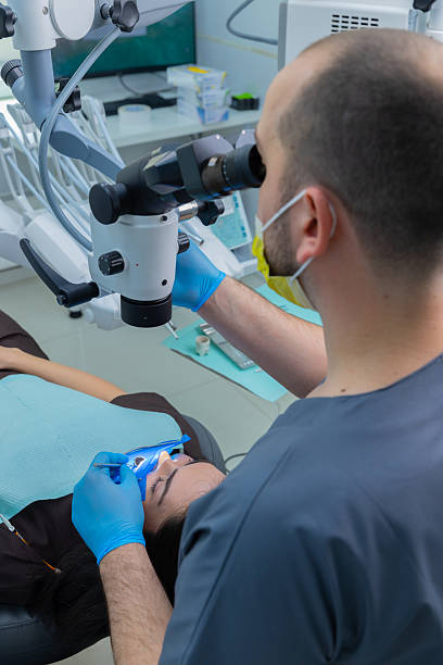 istock Professional Dentist Using Advanced Equipment to Perform Dental Procedure on a Female Patient in Modern Clinic, Showcasing Care and Precision in Oral Healthcare Services 2225371381