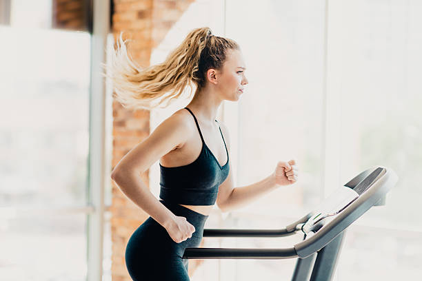 istock Active woman practicing cardio training on a treadmill indoors in gym environment, maintaining fitness and health 2225371531