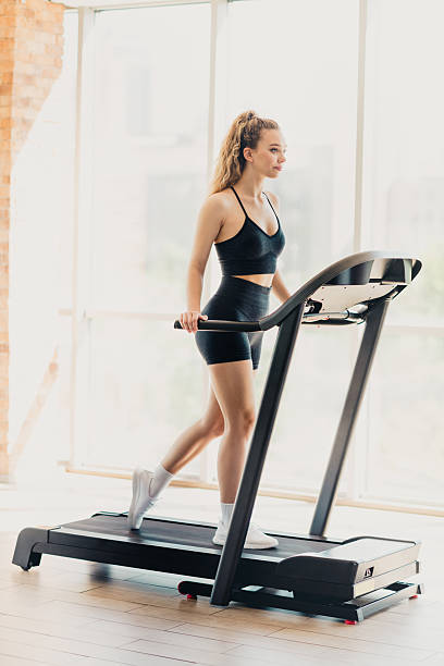 istock Athletic active woman exercising on a modern treadmill in a bright interior gym, practicing healthy lifestyle and sports. 2225371653