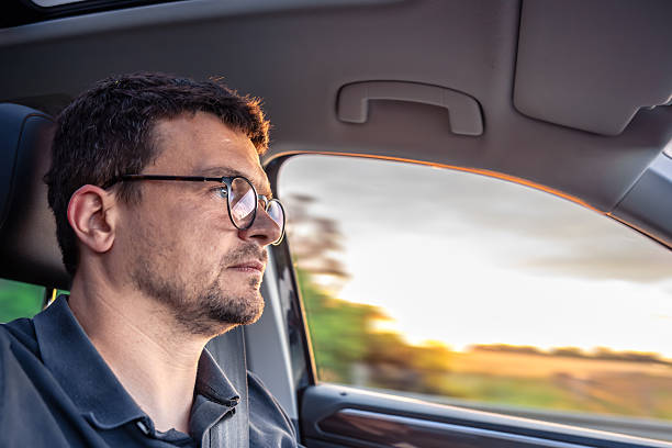 istock Driver side profile. Focused man in car. Sunset view outside 2225371900