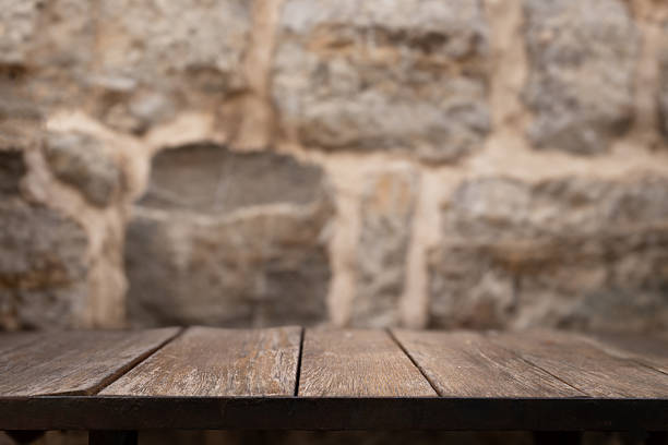istock Wooden table mock up with stone wall background. Empty wooden table copy space close up surface template place for product placement and advertisement soft cozy background 2225372356