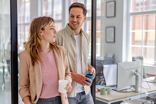 istock Team members engage in a casual conversation while enjoying coffee in a modern office setting 2225376330